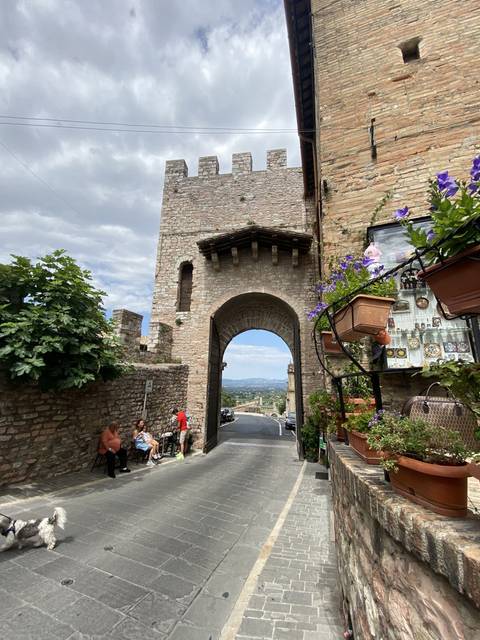       Historic stone archway with people walking through.
  