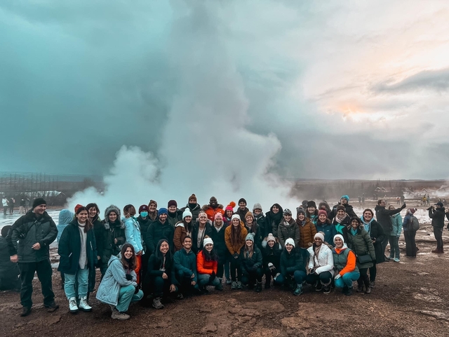Large group of people in front of a geyser.