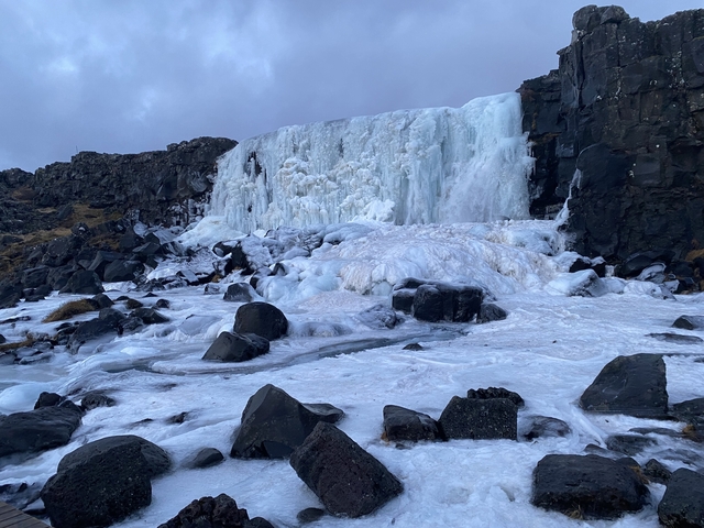Frozen waterfall with icy landscape.
