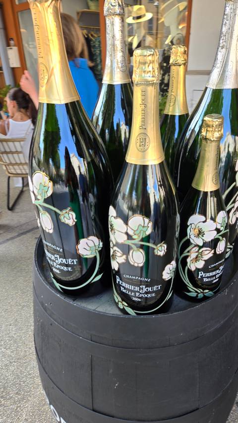 Several bottles of Perrier-Jouët champagne displayed outdoors.