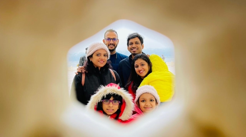 Family portrait through a stone frame, smiling faces with bright clothes.