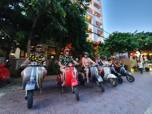       A group of people on colorful vintage scooters.
  
