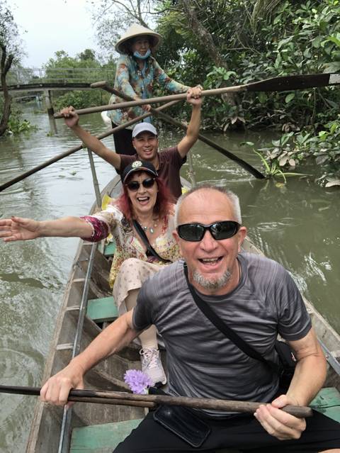       Group of people in a small boat on a river.
  