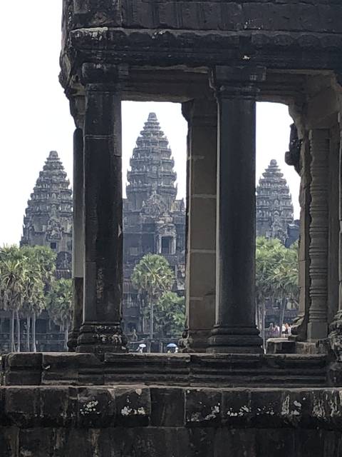       View of Angkor Wat temple through stone columns.
  