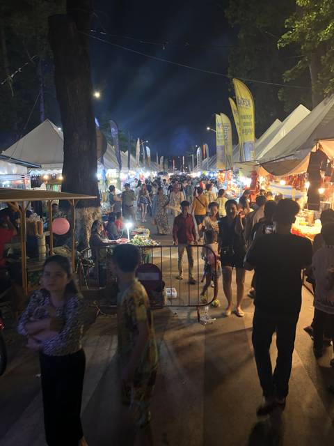       Night market with people walking around.
  