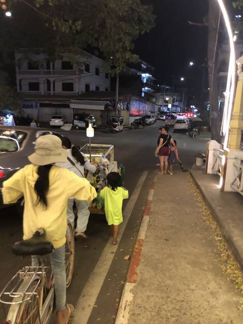       People walking along a street at night.
  