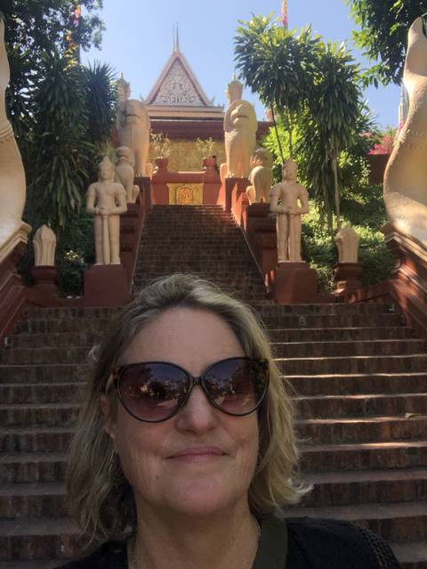      Woman taking a selfie in front of temple statues.
  