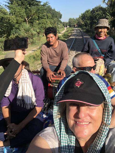       People sitting on a bamboo train in Cambodia.
  