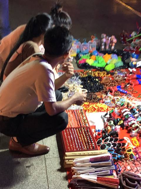      Couple browsing items at a night market.
  