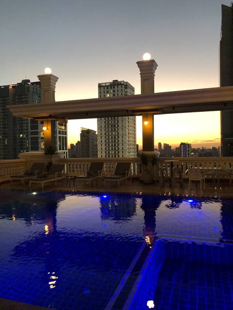      Swimming pool and cityscape at sunset.
  
