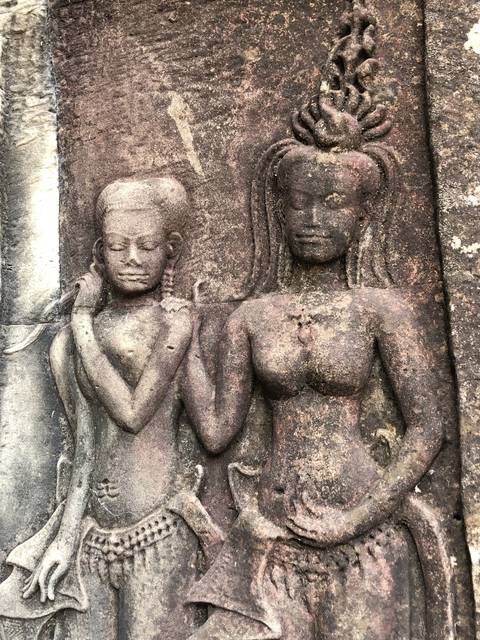       Close-up of ancient stone carvings depicting two figures.
  
