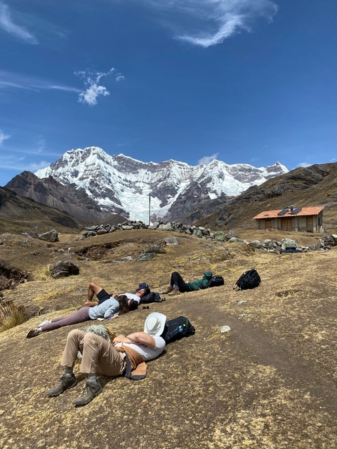 People resting in front of snowy mountains.