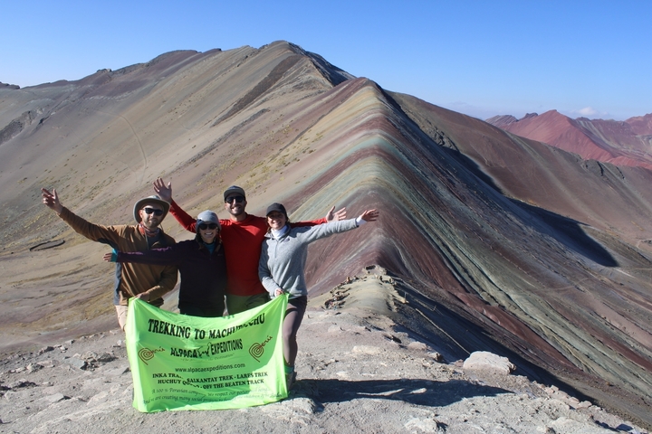 Group posing with a banner at Rainbow Mountain.