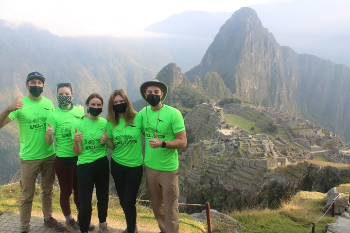 Group posing with matching shirts at Machu Picchu.