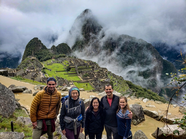       Group of people posing at Machu Picchu ruins.
  