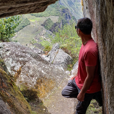       Man looking at Machu Picchu from a viewpoint.
  