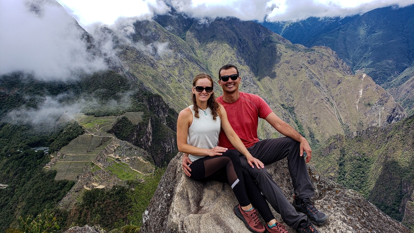       Couple sitting on a rock with Machu Picchu view.
  