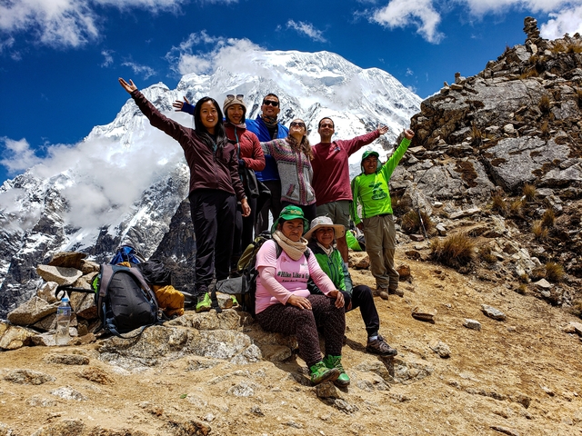       Group of hikers celebrating at a mountain peak.
  