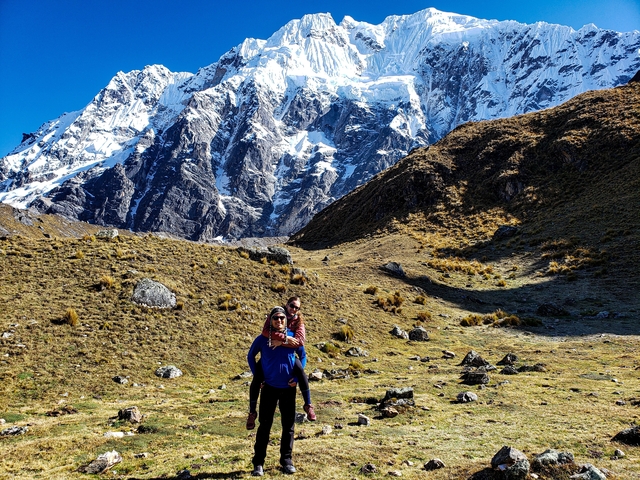       Couple in a mountainous landscape with clear skies.
  