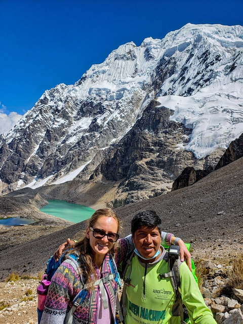       Couple in front of snowy mountains and turquoise lake.
  