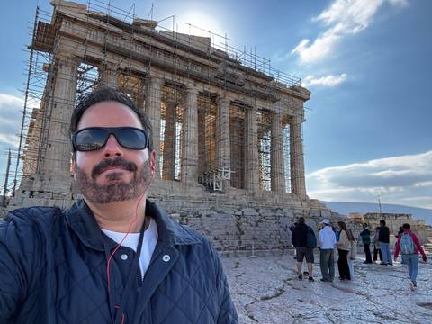 Person standing in front of the Parthenon.
