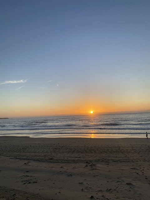       Sunset over the ocean with waves.
  
