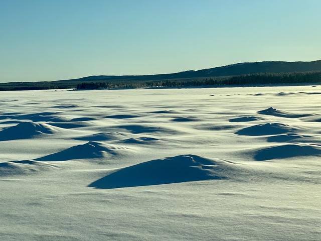 Snow-covered undulating landscape.