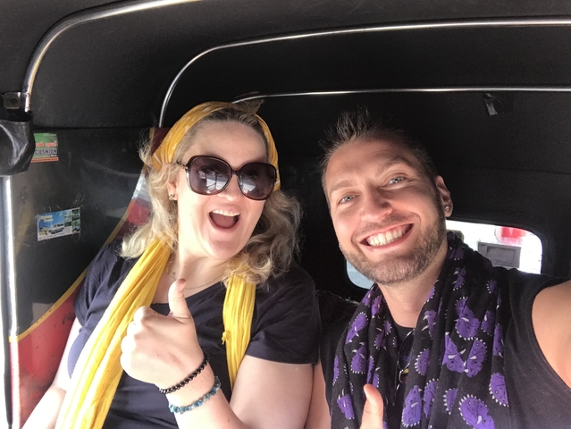       Two people in a tuk-tuk giving thumbs up.
  