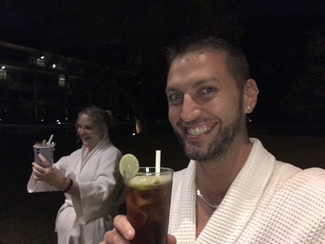       Two people in robes enjoying drinks at night.
  