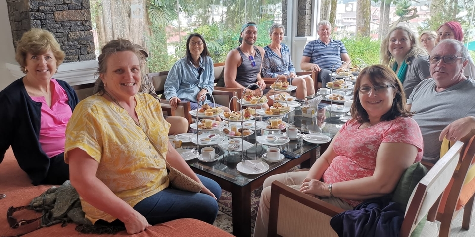 Group enjoying a high tea with desserts.