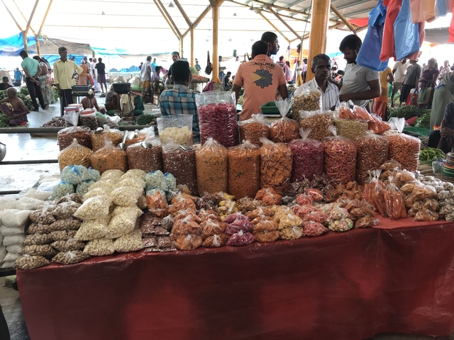 Market stall with various spices and snacks.