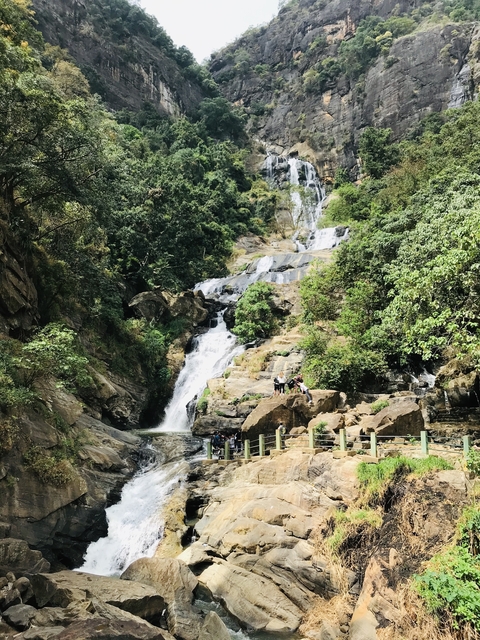       Waterfall with people at the base.
  