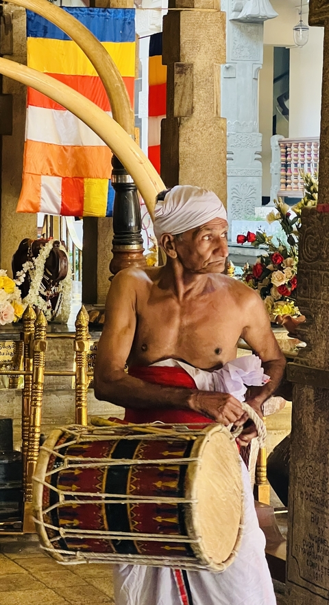 Man in traditional attire inside a temple.