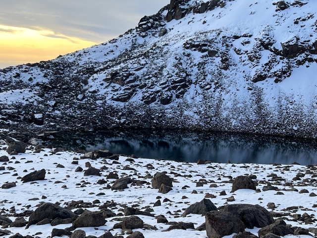       Snow-covered landscape with a small lake.
  
