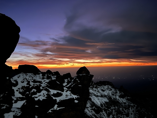       Snowy landscape at sunset with vibrant sky.
  