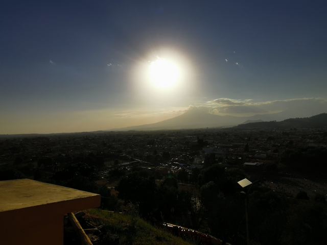       Sunset over a city view with distant mountains.
  