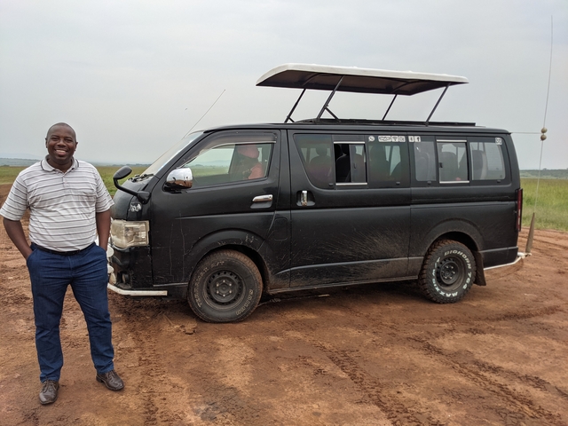       A person standing next to a safari van.
  