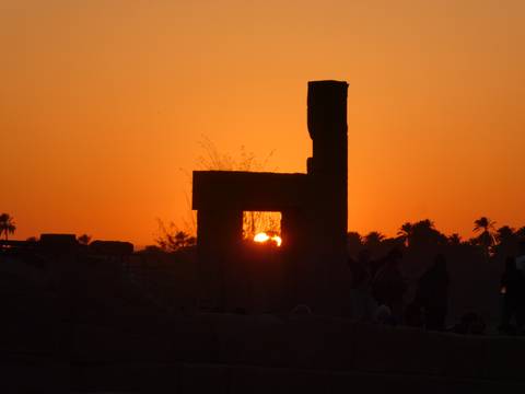 Silhouette of an ancient temple structure at sunset.