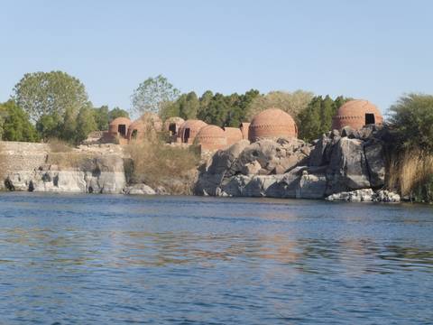       Nile River with dome-shaped structures by the shore.
  