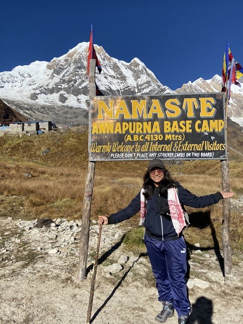       Person holding a sign at Annapurna Base Camp.
  