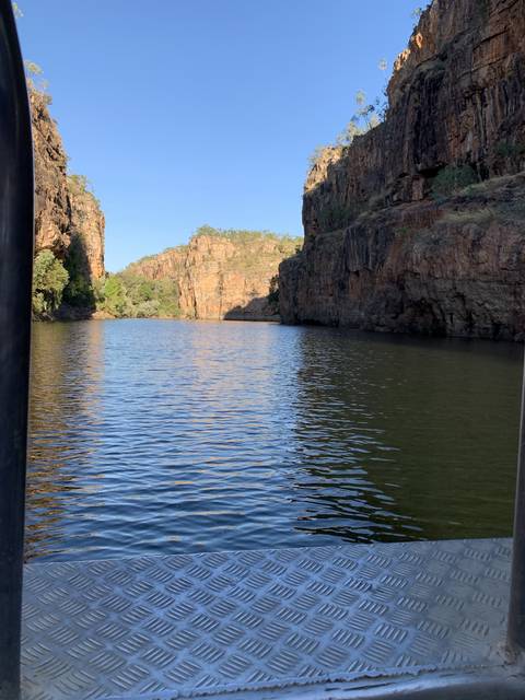       River flowing through rocky terrain with cliffs.
  