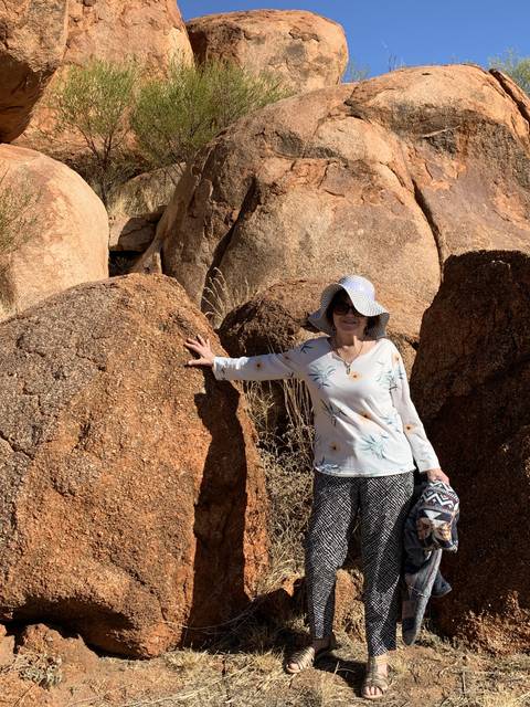       Person leaning on large rock formations.
  