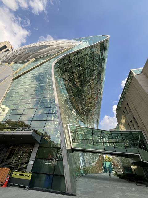       Modern glass building with reflection of sky.
  