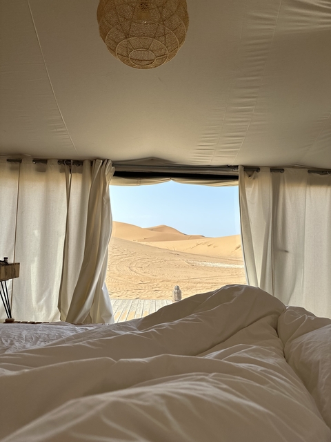 View of sand dunes from inside a tent
