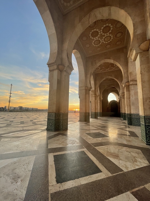 Ornate building with a courtyard and sunset background.