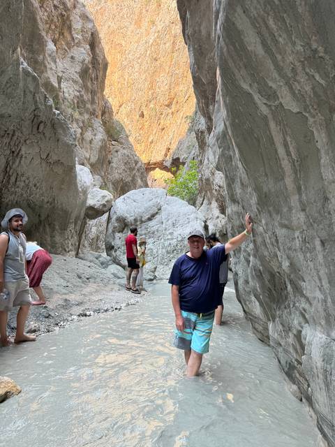 People posing in a rocky gorge with water.