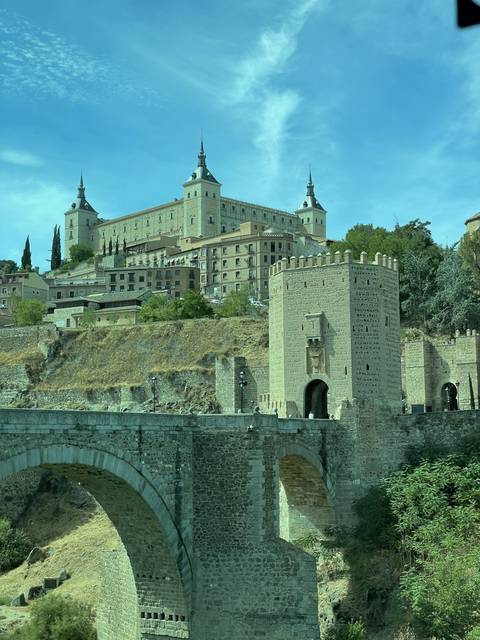 Old stone fortress with a bridge and blue sky.