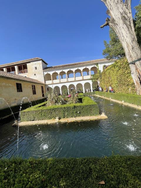 Courtyard garden with a water fountain and arched walkways.
