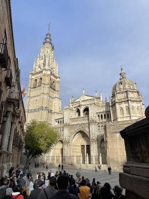A crowd in front of a large cathedral with intricate stonework.
