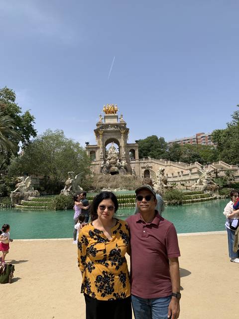 Couple posing in front of a fountain and monument.